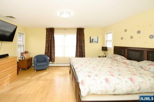 1-06 Lambert Rd, Fair Lawn, NJ 07410 - bedroom featuring visible vents, light wood finished floors, and baseboard heating