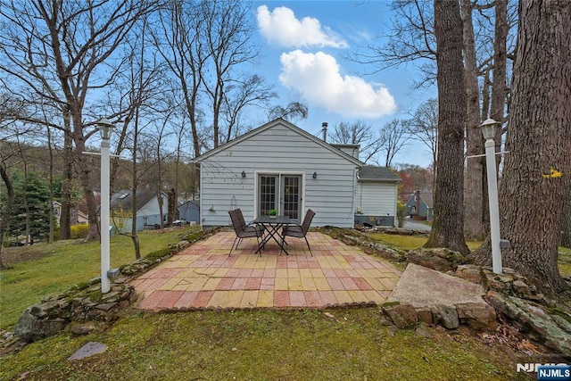 back of property featuring a lawn and a patio