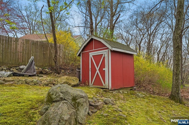 view of shed featuring fence