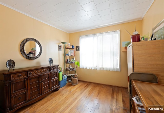 interior space with crown molding, light wood finished floors, and baseboards