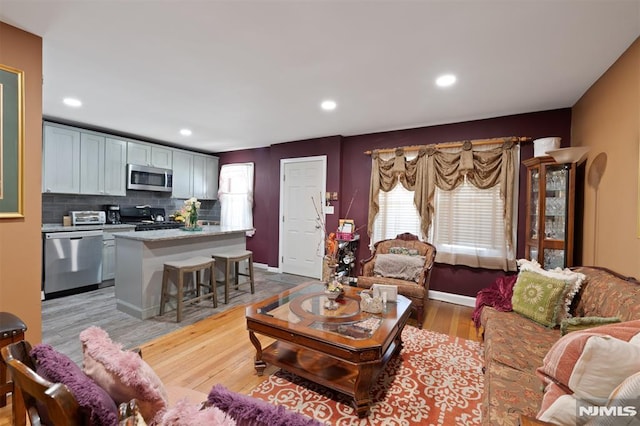 living area featuring recessed lighting, baseboards, and light wood-type flooring