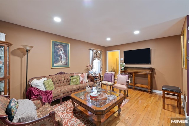 living area featuring light wood-style floors, baseboards, and recessed lighting