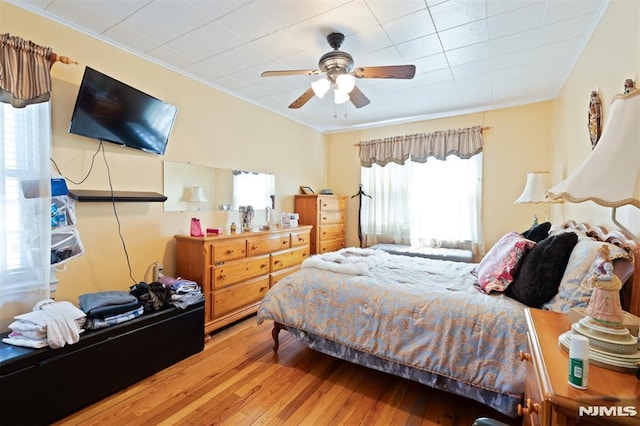 bedroom featuring crown molding, a ceiling fan, and hardwood / wood-style floors