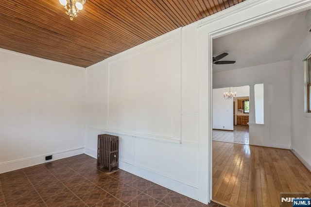 unfurnished room with baseboards, a notable chandelier, and wooden ceiling