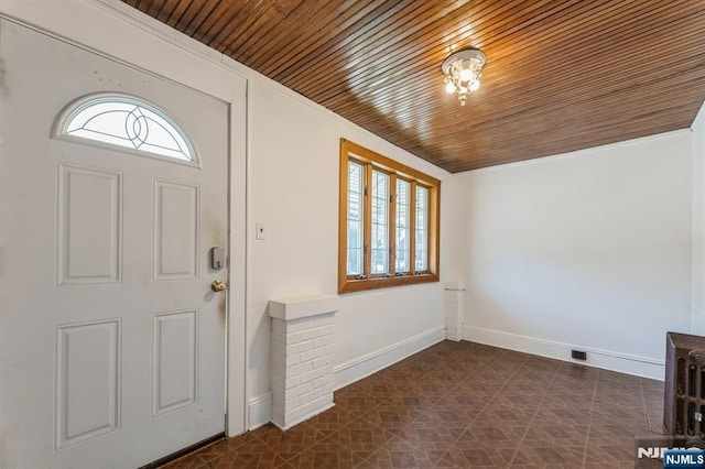 foyer entrance with plenty of natural light, wood ceiling, and baseboards