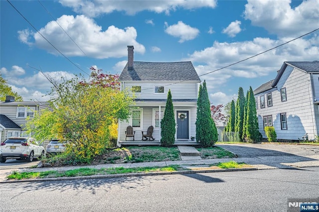 view of front of house with covered porch and a chimney