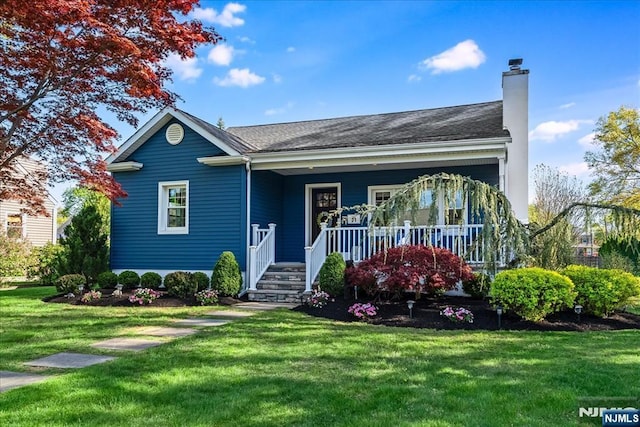view of front of house featuring a chimney, a porch, and a front lawn