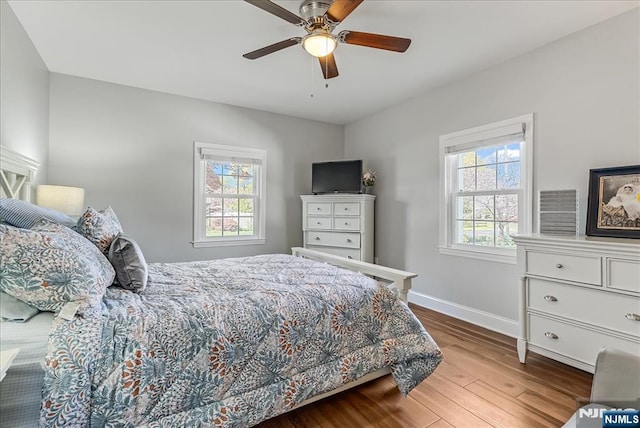 bedroom with baseboards, a ceiling fan, and wood finished floors