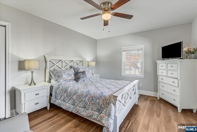 bedroom with a ceiling fan, baseboards, and wood finished floors