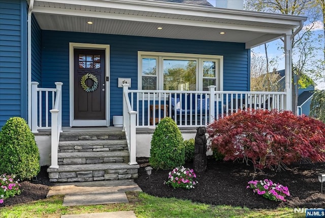 doorway to property with covered porch and a chimney