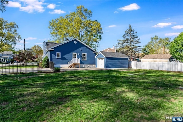 back of house with a lawn, fence, and an outbuilding