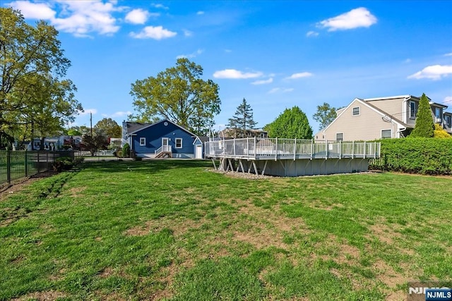 view of yard with a fenced in pool, fence, and a deck