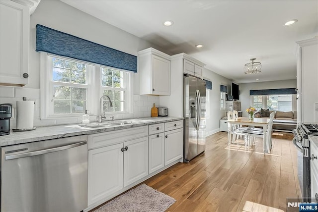 kitchen featuring a sink, appliances with stainless steel finishes, a wealth of natural light, and light wood-type flooring