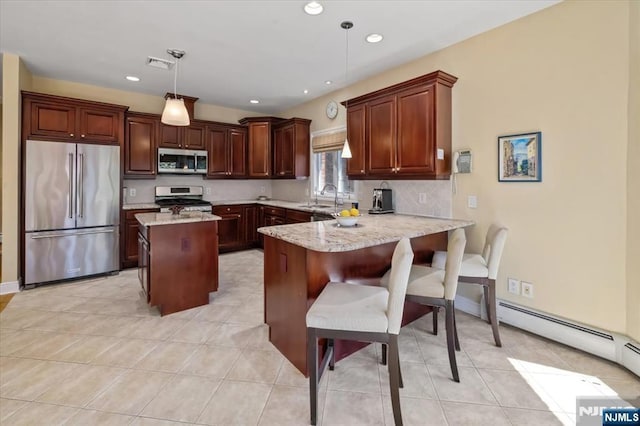 kitchen with visible vents, a sink, a baseboard heating unit, a peninsula, and stainless steel appliances