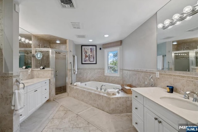 full bath with visible vents, a shower stall, and a sink