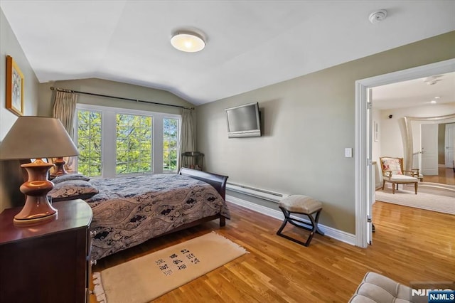 bedroom featuring wood finished floors, baseboards, lofted ceiling, and baseboard heating