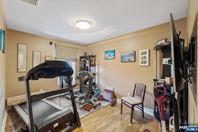 workout room featuring baseboards and wood finished floors
