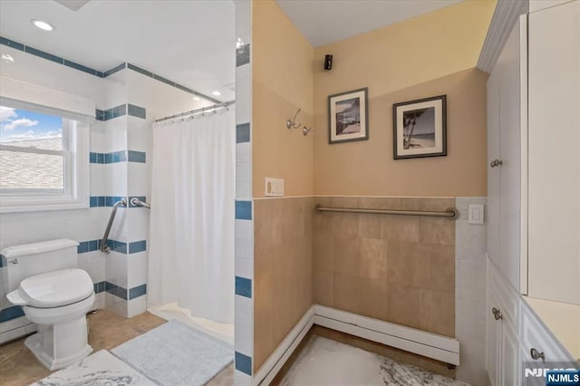 bathroom featuring tile patterned flooring, wainscoting, toilet, tile walls, and a shower with shower curtain