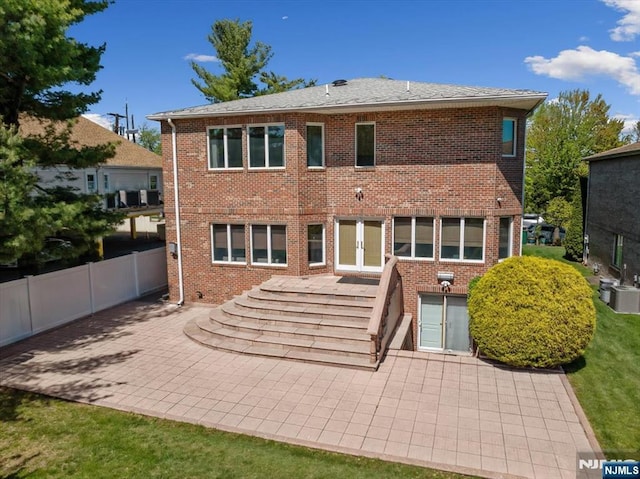 back of house with brick siding, fence, central AC unit, and a patio area