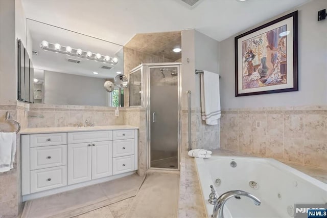 full bathroom featuring vanity, tile patterned floors, a jetted tub, a shower stall, and visible vents