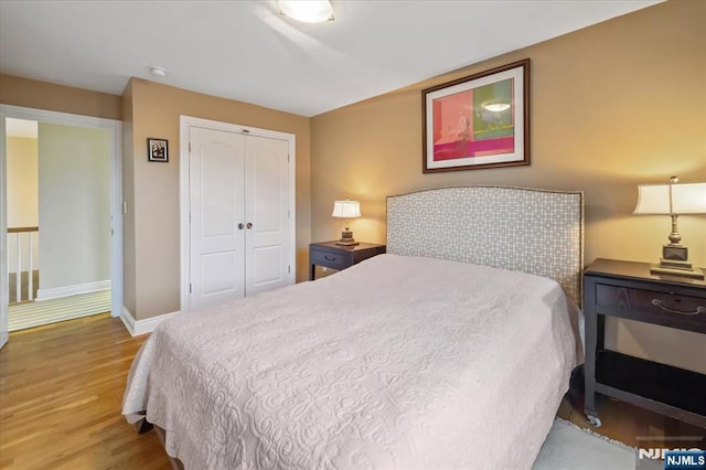 bedroom with baseboards, a closet, and wood finished floors