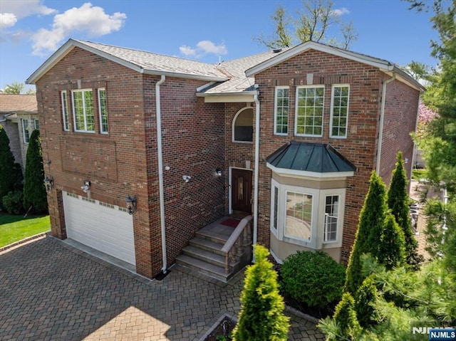 view of front of house featuring brick siding, driveway, and a garage