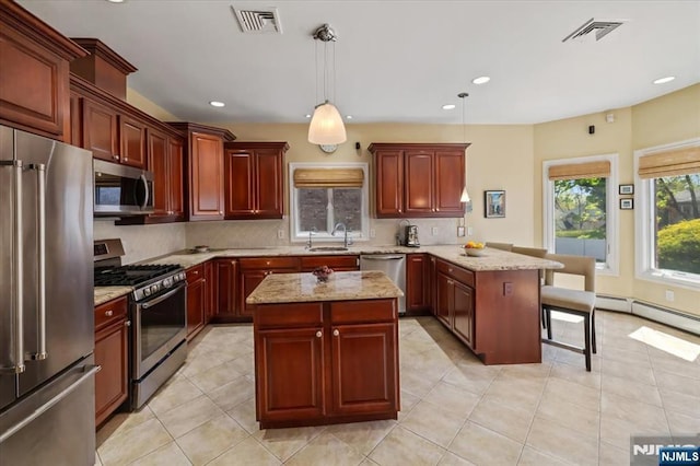 kitchen featuring decorative backsplash, visible vents, a sink, a peninsula, and stainless steel appliances