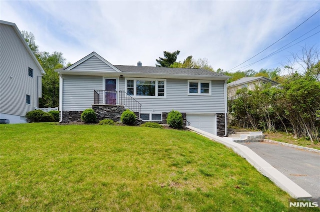 single story home featuring an attached garage, driveway, and a front lawn