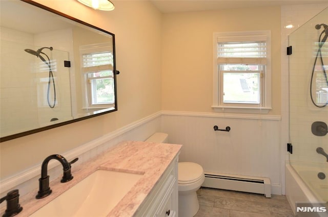bathroom featuring toilet, plenty of natural light, baseboard heating, and vanity
