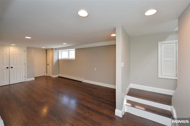 basement featuring recessed lighting, wood finished floors, and baseboard heating