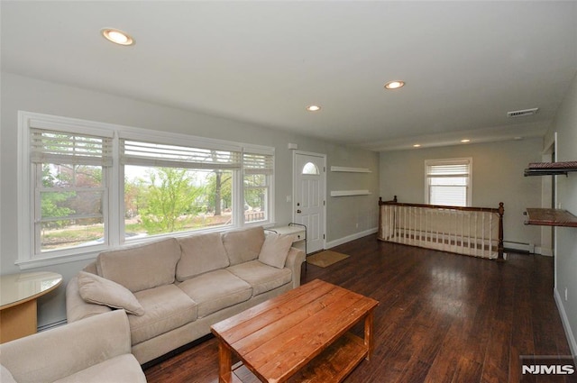 living area with recessed lighting, baseboards, wood finished floors, a baseboard heating unit, and visible vents
