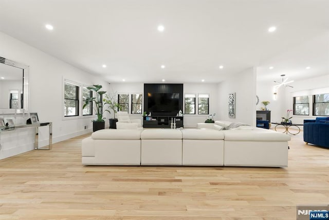 living room featuring recessed lighting, a wealth of natural light, and light wood-style flooring