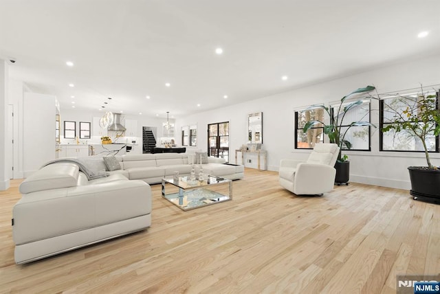 living room with recessed lighting, baseboards, a chandelier, and light wood-type flooring