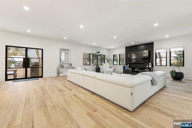 living room featuring recessed lighting, light wood-style floors, and a wealth of natural light