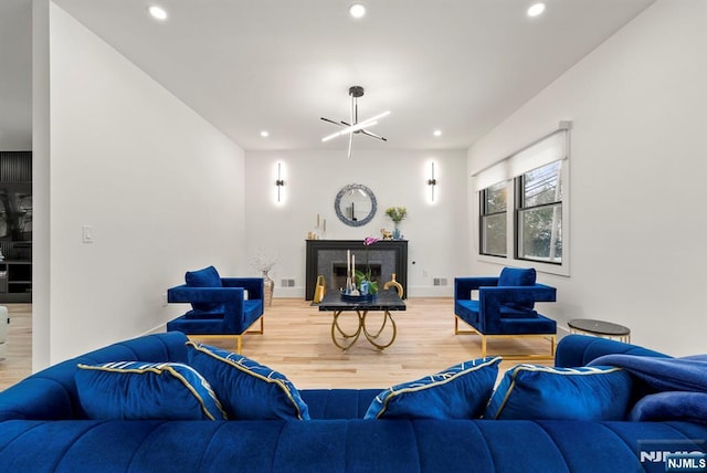 living room featuring recessed lighting, visible vents, wood finished floors, and a fireplace