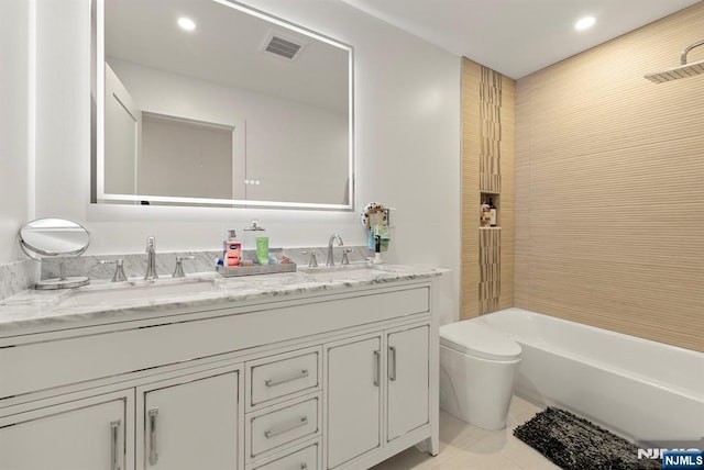 full bath with a tub, double vanity, visible vents, a sink, and toilet