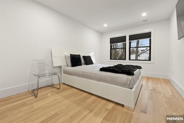bedroom with baseboards, recessed lighting, light wood-style flooring, and visible vents