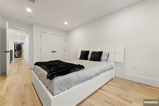 bedroom featuring recessed lighting, baseboards, light wood-style flooring, and a closet