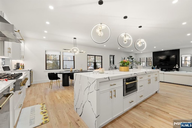 kitchen with light wood-style floors, range hood, stainless steel appliances, and recessed lighting