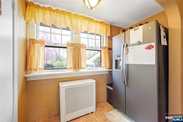 6 Colonial Ct, Dumont, NJ 07628 - kitchen featuring stainless steel fridge, light tile patterned flooring, radiator heating unit, and a healthy amount of sunlight