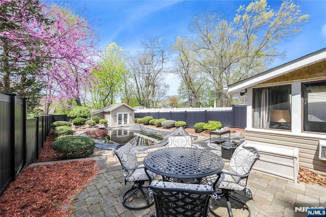 6 Colonial Ct, Dumont, NJ 07628 - view of patio with an outdoor structure, a fenced backyard, and outdoor dining area