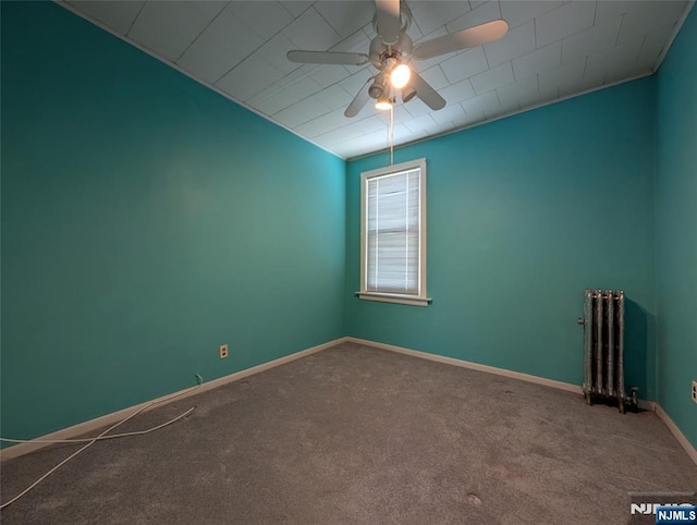unfurnished room with radiator heating unit, baseboards, ceiling fan, and carpet