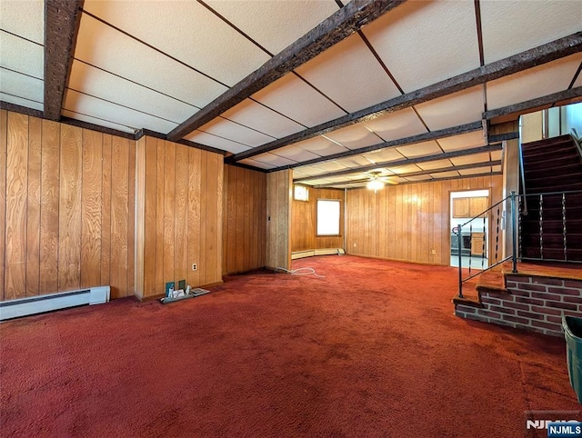 below grade area with wooden walls, carpet flooring, stairs, and a baseboard heating unit