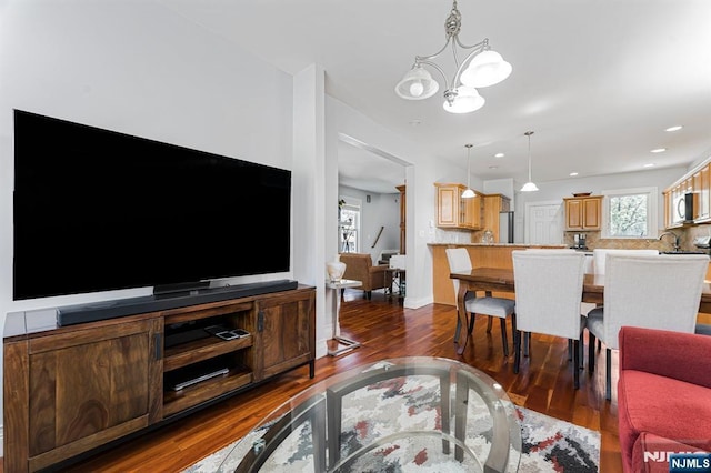 living area featuring dark wood-style flooring, a notable chandelier, and recessed lighting