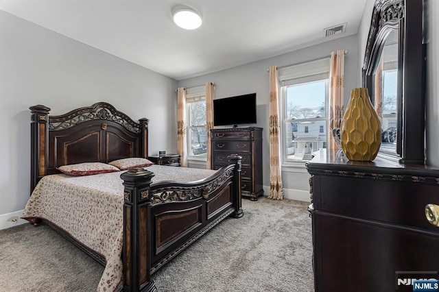 bedroom with baseboards, visible vents, and light colored carpet