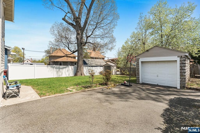 detached garage with fence and driveway