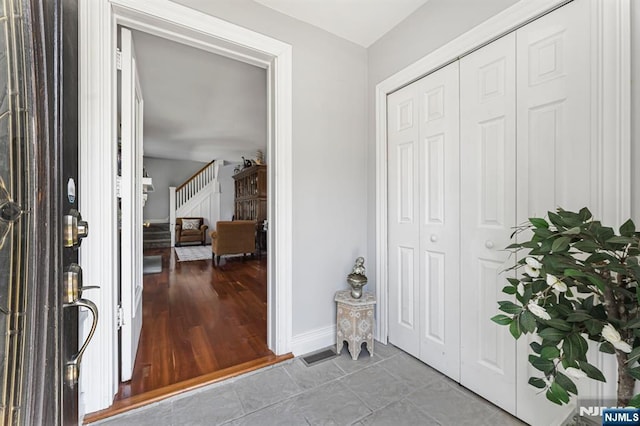 entrance foyer with baseboards, visible vents, and tile patterned floors