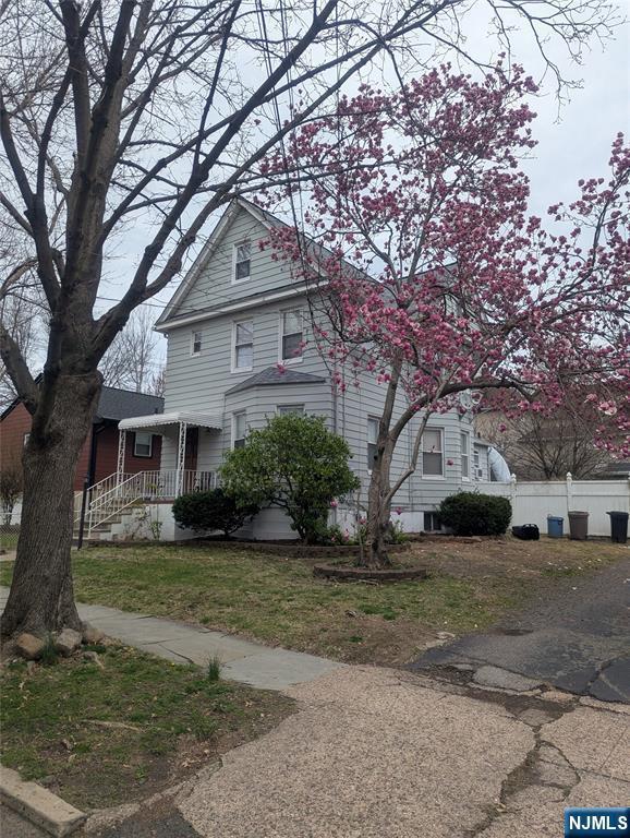 victorian house featuring fence and a front lawn