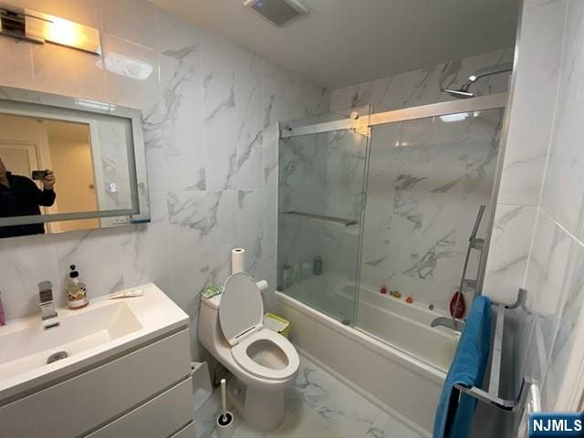 48 Legend Hills Dr, Edgewater, NJ 07020 - full bathroom with vanity, marble finish floor, toilet, tile walls, and enclosed tub / shower combo