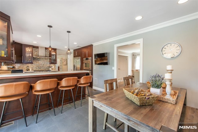 dining space with recessed lighting, baseboards, crown molding, and tile patterned flooring